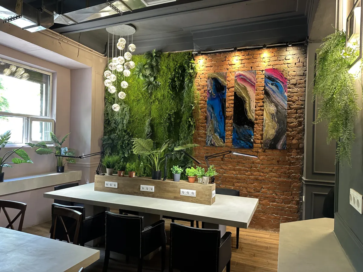 Зал кофейни: фитостена, кирпич и общий стол с зеленью